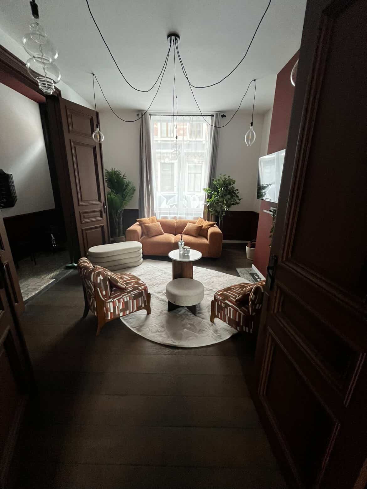 Salon avec canapé terracotta et fauteuils design après nettoyage par EasyProClean